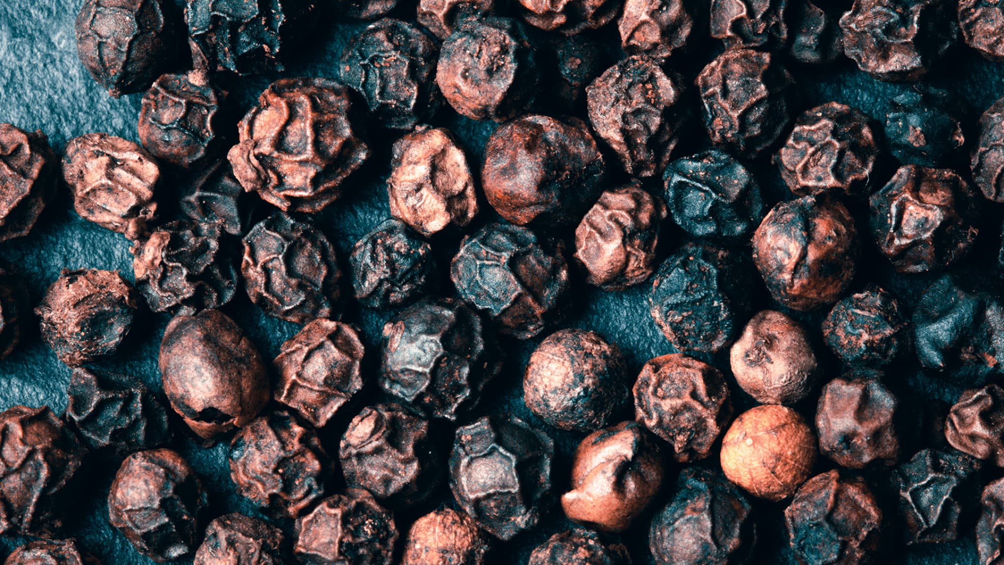 Grãos de pimenta do reino representando a cultura.